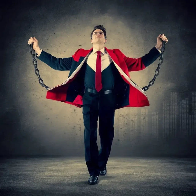 Man In Suit Overcoming Imposter Syndrome By Holding a Chain, Representing Breaking Free.